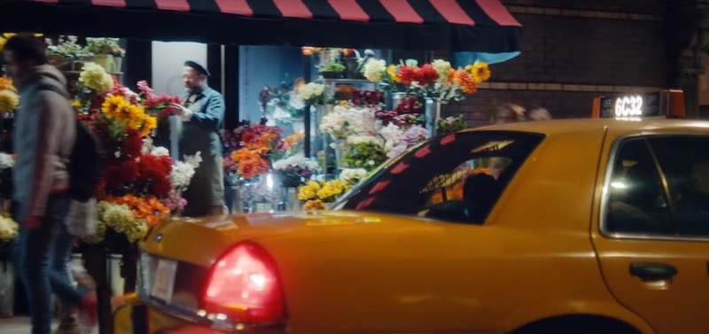 A still from the Michael Bublé fragrance advert: a yellow taxi passing a flower stall at night